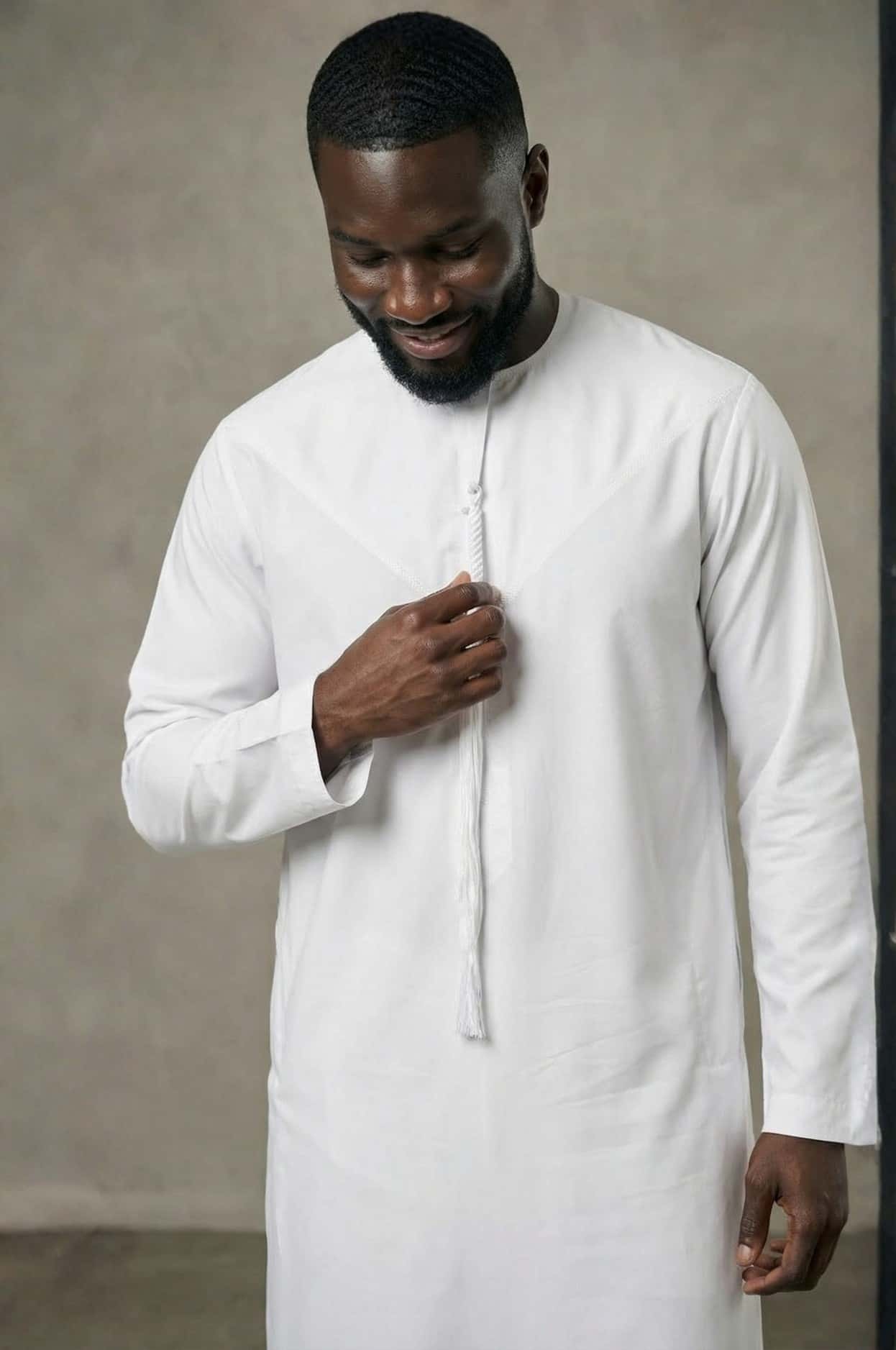 Sophisticated international businessman wearing a crisp white premium kandora in a luxury Abu Dhabi setting, exuding confidence and elegance. 2