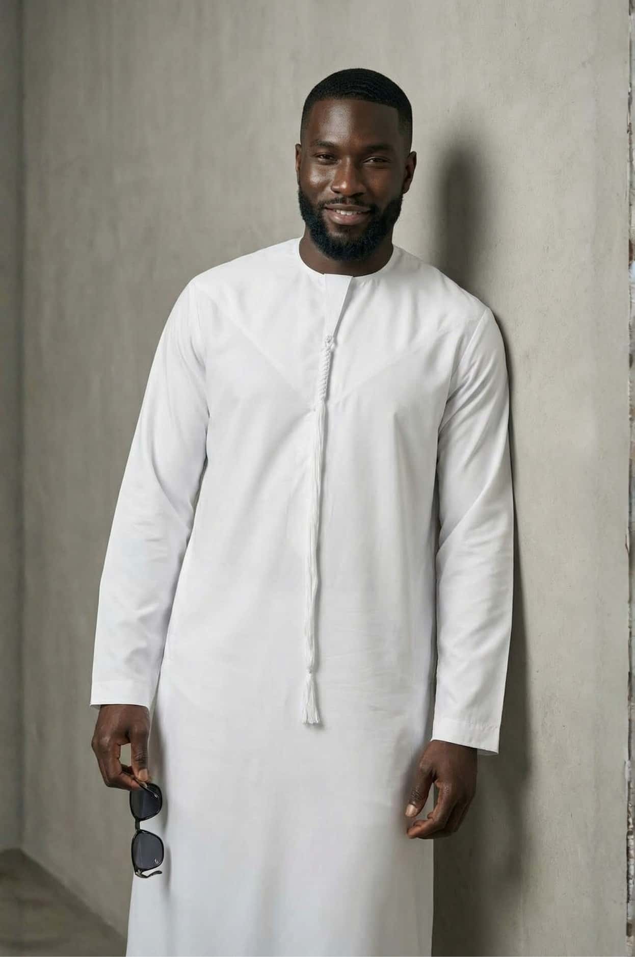 Sophisticated international businessman wearing a crisp white premium kandora in a luxury Abu Dhabi setting, exuding confidence and elegance. 3