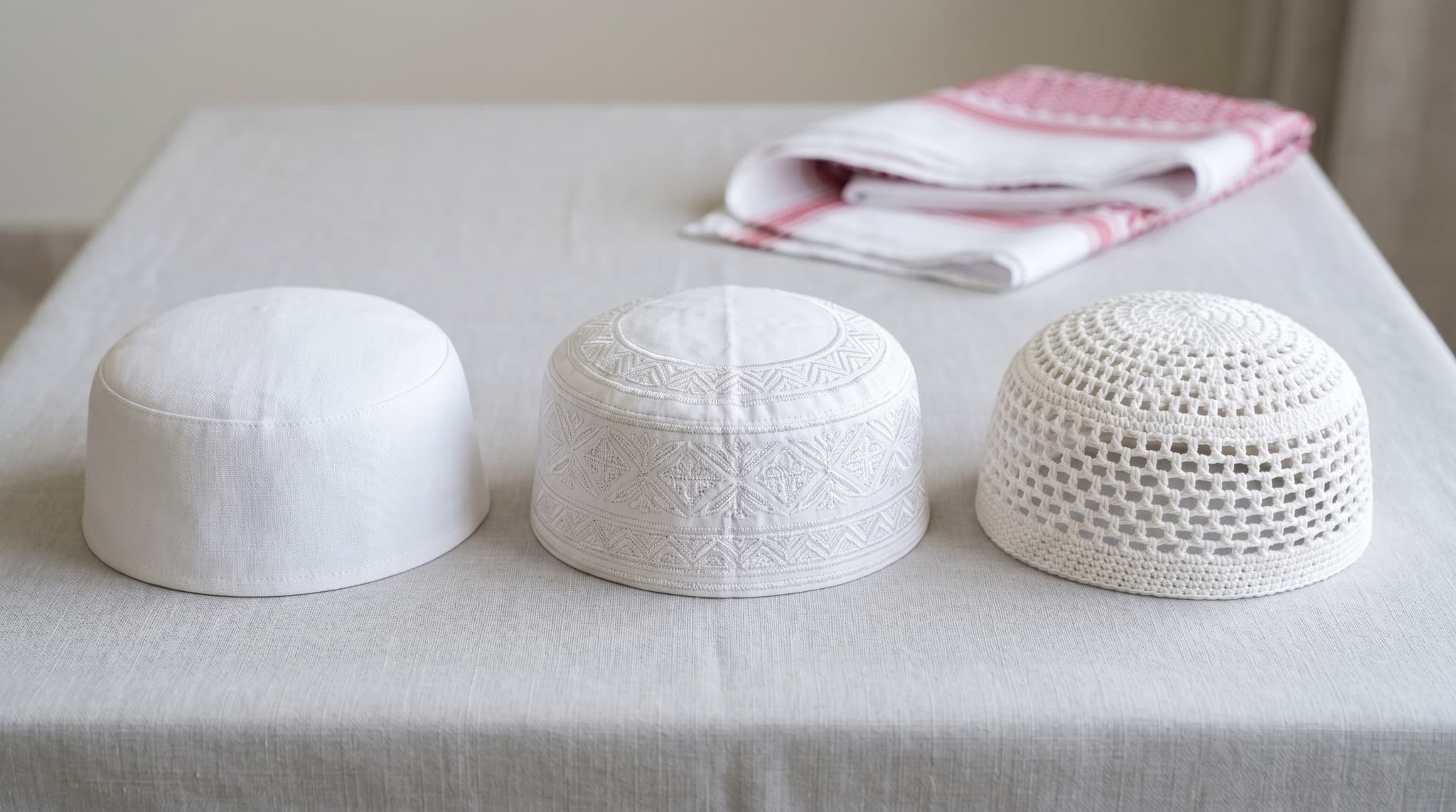 Three Gahfiya caps arranged neatly on a clean light grey surface