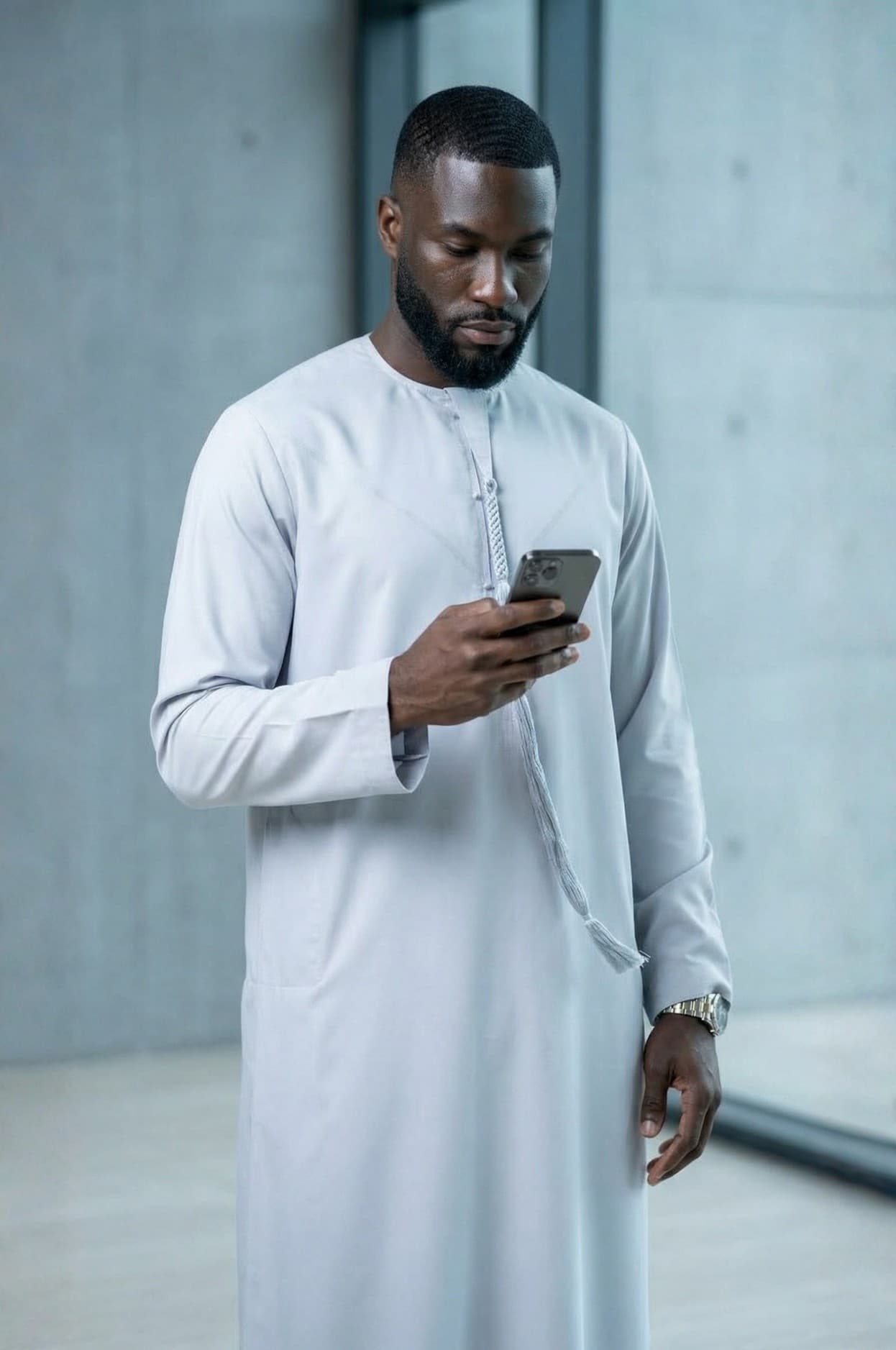 Modern professional wearing an ice grey kandora against Abu Dhabi's contemporary skyline, representing future luxury in traditional dress. 1