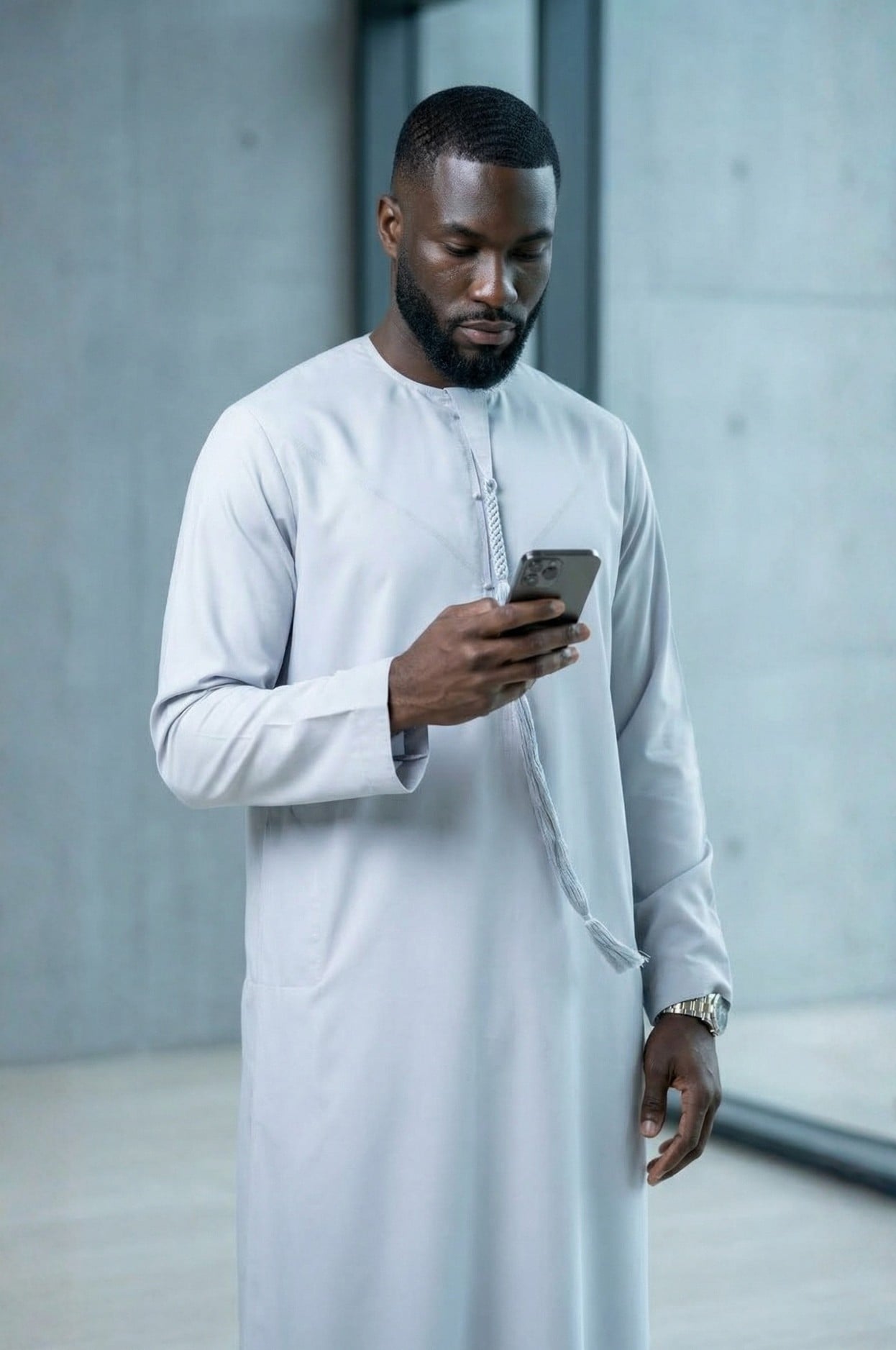 Modern professional wearing an ice grey kandora against Abu Dhabi's contemporary skyline, representing future luxury in traditional dress. 1